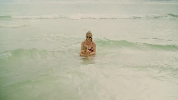 Glückliche junge Mutter und ihr kleines Mädchen haben Spaß im Wasser des Ozeans am panama city beach usa — Stockvideo