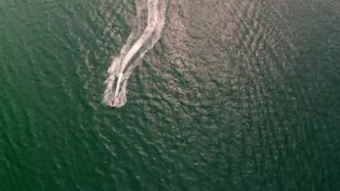 Sahile yakın seyreden bir motorlu teknenin havadan görüntüsü.