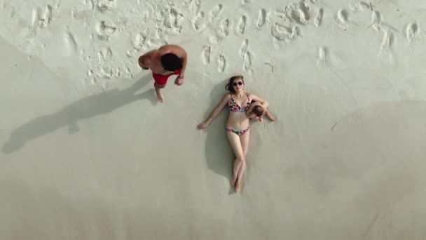 家族はビーチの空中展望ドローンショットに横たわっ — ストック動画