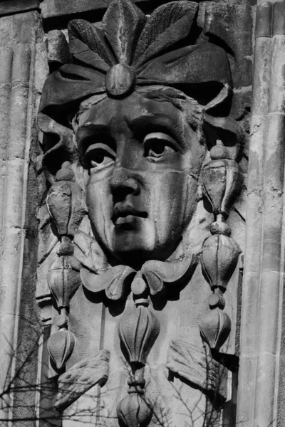 Stucco molding on the building - the head of a beautiful woman.