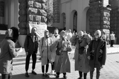 Kiev, Ukraine - March, 13, 2020: people in protective suits and a passerby figure out how to avoid the disease.