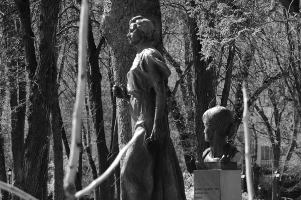 Cast-iron female sculptures: a slim figure and a beautiful head - in the park.
