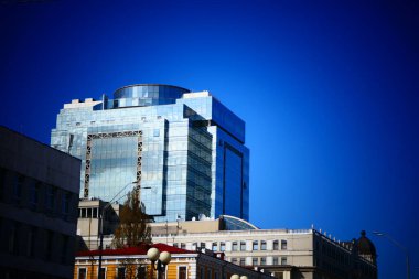 Cam bina, açık mavi gökyüzünü gösteren yuvarlak bir üst yapısı olan modern tarzda kare şeklindedir..