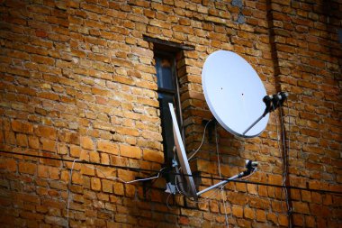 Yeni uydu çanaklarının takıldığı dar eski pencere çok garip görünüyor..