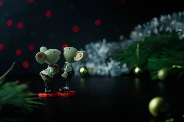 A couple of mice toy, symbol of Chinese happy new 2020 on dark background table and new year pine. New Year \'s 2020 Symbol. Christmas rat or mouse concept. Place for text.