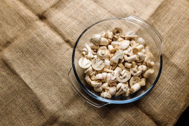 Orman şampiyonu mantarlarını cam kasede keselim. Masanın üzerinde çuval bezle kaplanarak duralım. Vejetaryen, organik ve sağlıklı yiyecekler. Yeme alışkanlıkları, beslenme ve diyet konsepti. Metin için yer.