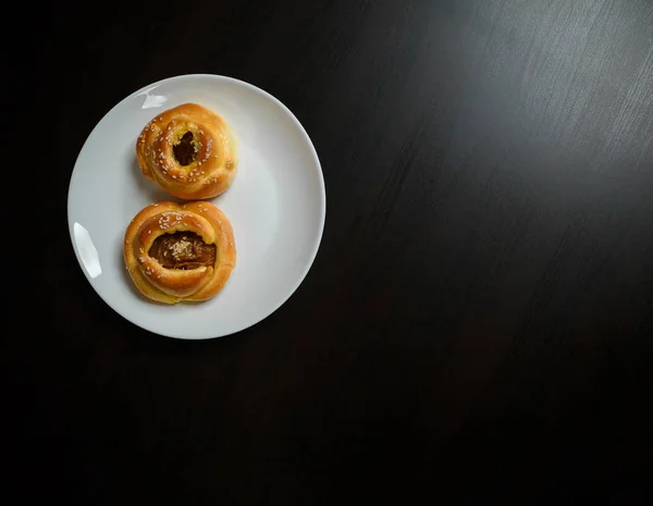 Heerlijke Sesambroodjes Taarten Witte Plaat Zwarte Houten Tafelondergrond Lekkere Ongezonde — Stockfoto