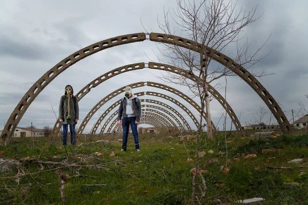 Gaz maskeli bir kız ve adam harabelerin ve dramatik gökyüzü geçmişlerinin arasında duruyor. Çevre kirliliği, ekoloji felaketi, radyasyon, biyolojik tehlike kavramı. Ukrayna 'da Savaş