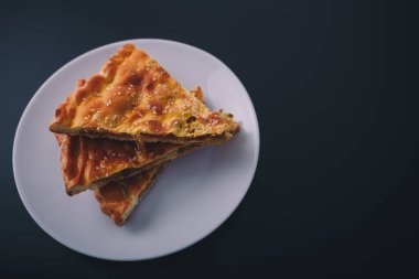 Siyah ahşap arka planda beyaz tabakta biraz et ve havuçlu turta. Lezzetli sağlıklı yiyecekler. Diyet, beslenme, yeme alışkanlıkları. Metin için yer.