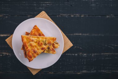 Siyah ahşap arka planda beyaz tabakta biraz et ve havuçlu turta. Lezzetli sağlıklı yiyecekler. Diyet, beslenme, yeme alışkanlıkları. Metin için yer.