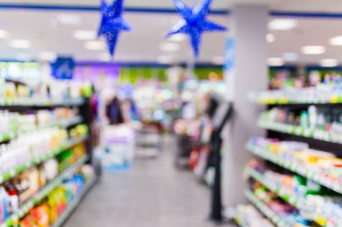 Süpermarketin iç mekanının odaklanmamış görüntüsü. Bulanık hipermarket, alışveriş merkezi ya da alışveriş merkezi geçmişi. Sıralar ve raflar ev kimyasallarıyla yıkanacak ve temizlenecek..