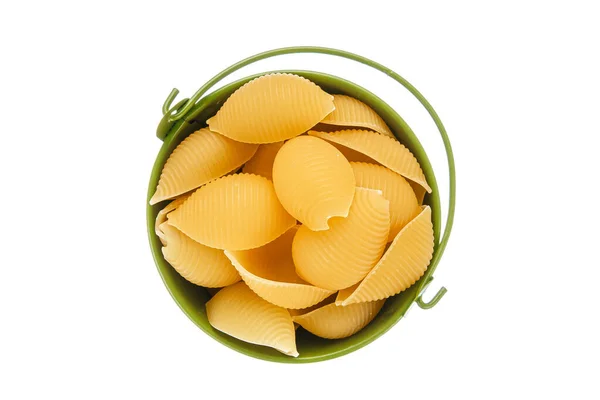 Conchiglie rigate makarna ya da yeşil kovada beyaz arka planda izole edilmiş deniz kabuklu makarna. İtalyan mutfağı, karbonhidratlı sağlıklı yiyecekler, diyet, beslenme. Üst görünüm. 
