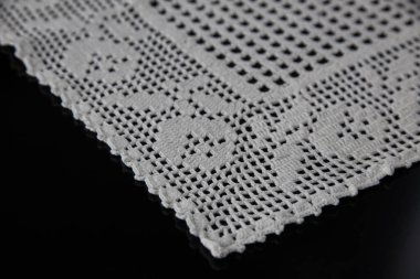 Tığ işi peçeteler, siyah arka planda beyaz dantel.