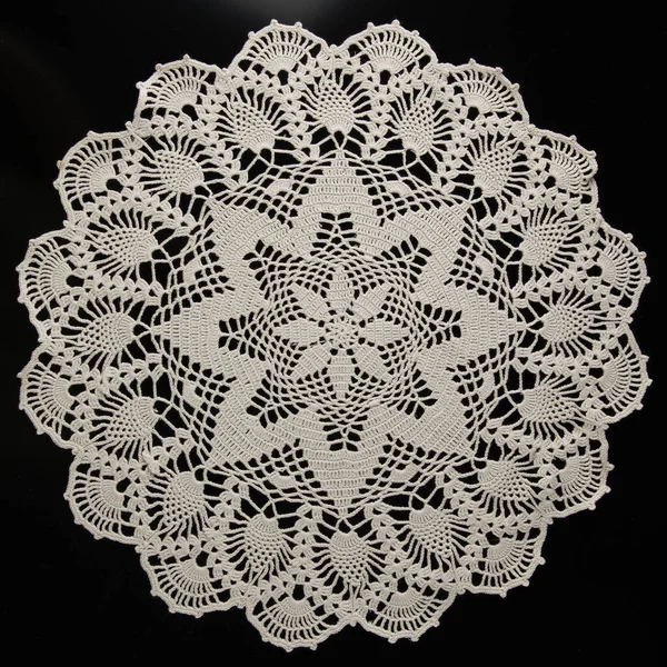 crocheted napkins, white lace on a black background