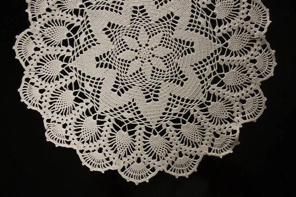 crocheted napkins, white lace on a black background