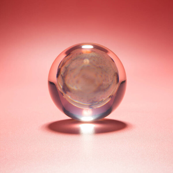 seashell in a glass ball on a pink background