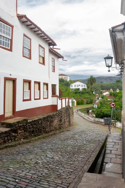 Vertical landscape with cobbled street, colonial houses and moun — Stock Photo, Image