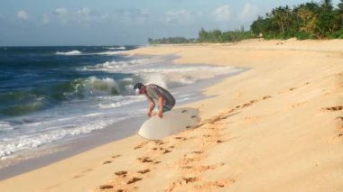 Sahilde mükemmel dalgalar için bekleyen genç sörfçü