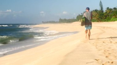 Surfboard holding ve Hawaii plajda yürüyüş sörfçü