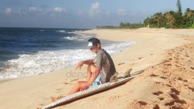 Sahilde mükemmel dalgalar için bekleyen genç sörfçü