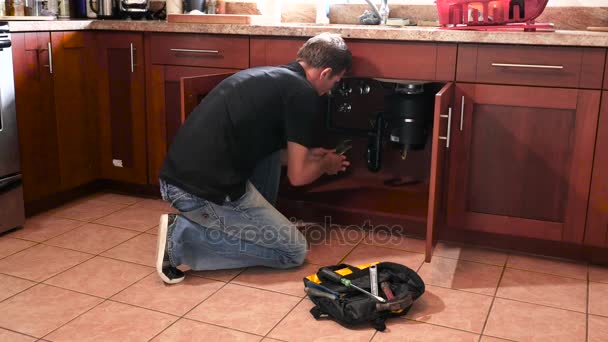 Водопроводчик с инструментами на кухне. Сантехника и ремонт — стоковое видео
