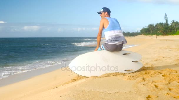 Юный серфер на пляже в ожидании идеальных волн — стоковое видео