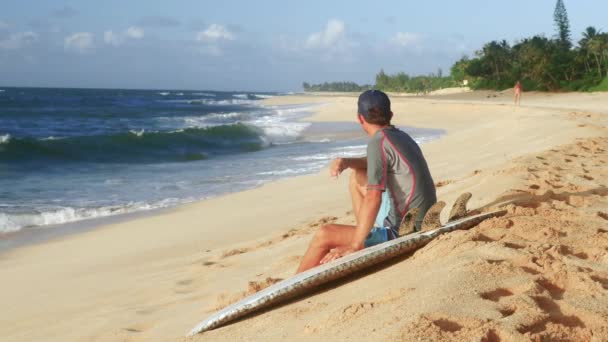 Jonge surfer op het strand te wachten voor perfecte golven — Stockvideo