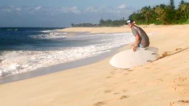 Mladý surfař na pláži čeká perfektní vlny — Stock video