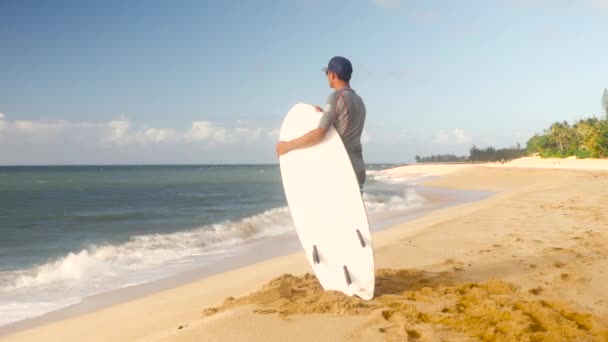Юный серфер на пляже в ожидании идеальных волн — стоковое видео