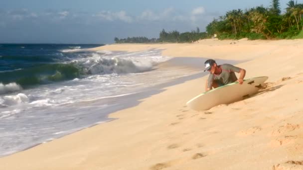 Uma prancha de depilação surfista antes de surfar no Havaí — Vídeo de Stock