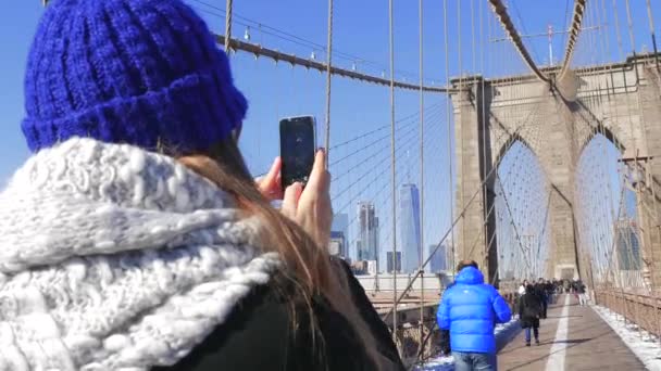 브루클린 브리지 뉴욕에 그녀의 스마트 폰으로 사진을 찍고 젊은 여성 관광객 — 비디오