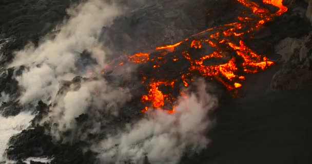 Éruption volcanique Lave coulant dans l'eau Hawaï la nuit 