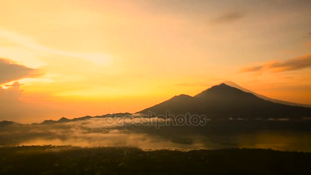 Salida del sol sobre el lago Batur, Volcán Agung y Abang en el fondo. Bali. — Vídeo de stock