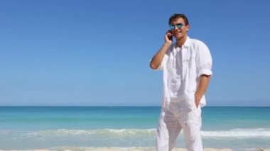 Hawaii plaj tatil seyahat kavramı üzerinde akıllı telefonda konuşan genç adam