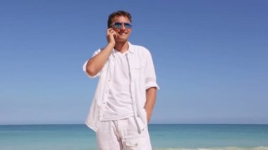 Hawaii plaj tatil seyahat kavramı üzerinde akıllı telefonda konuşan genç adam