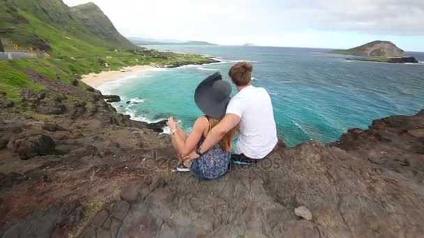 Młoda para active siedzi i ogląda widok w Makapuu Lookout, Oahu na Hawajach — Wideo stockowe