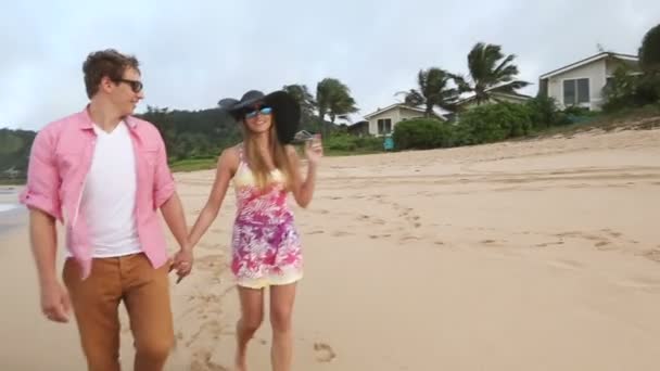 Kärleksfull unga kaukasiska par hålla händerna promenader tillsammans beach Oahu Hawaii — Stockvideo