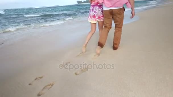 Amar joven pareja caucásica cogidos de la mano caminando juntos playa Oahu Hawaii — Vídeo de stock