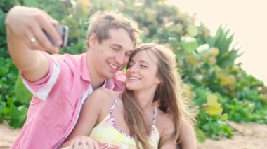 Gülümseyen genç iki sevgi sahil üzerinde kendi kendine portre fotoğraf makinesi telefon ile aldıktan sonra