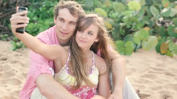 Sonriendo joven pareja enamorada de tomar autorretrato con cámara de teléfono en la playa — Vídeo de stock