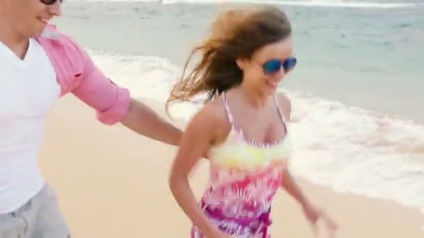 一緒にビーチで実行されて楽しい魅力的な健康的なカップル — ストック動画