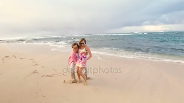 Attractive healthy couple having fun being together running on beach — Stock Video