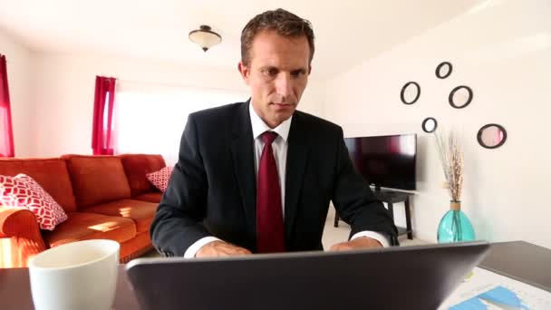 Кавказский бизнесмен работает дома за ноутбуком — стоковое видео
