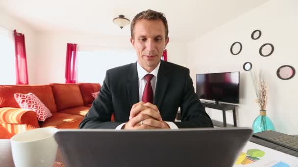 Ένας νεαρός επιχειρηματίας ασχολείται με μια κλήση βίντεο με έναν πελάτη στο σπίτι — Αρχείο Βίντεο