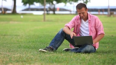Laptop üstünde hareket eden telefon parkta konuşma ile adam