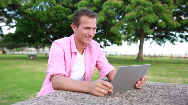 Um jovem conversando no laptop ao ar livre — Vídeo de Stock