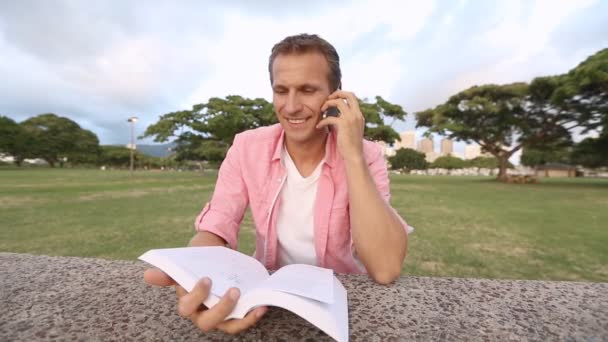 Hombre hablando por teléfono en el parque — Vídeos de Stock