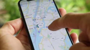 Telefonuyla seyrüsefer uygulaması kullanan ve New York 'ta popüler yerlere seyahat yolları arayan bir adam. Cep telefonu ekranı yakın çekim. Yol Haritası