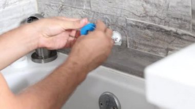 Tesisatçı duşu tamir ediyor. İşçi banyoda duşu tamir ediyor. Man Muslukçu banyodaki duştaki sızıntıyı tamir ediyor, 4K video