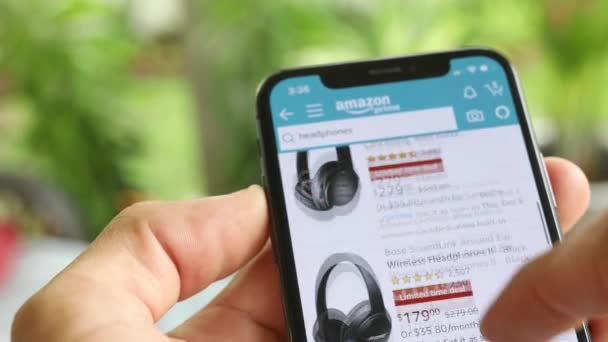 Man Zoek Naar Koptelefoon Amazon App Met Mobile Smart Iphone — Stockvideo